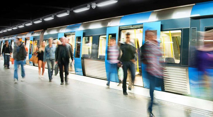 Metro passengers boarding train at busy station platform