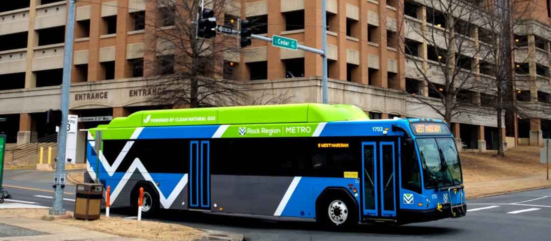 Electric city bus driving past urban parking structure