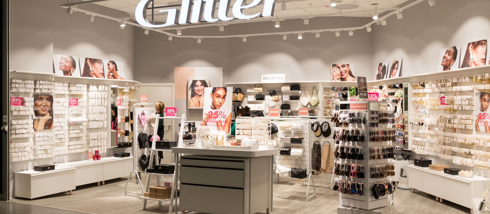 Bright jewelry retail store interior with displays, accessories, and promotional signage