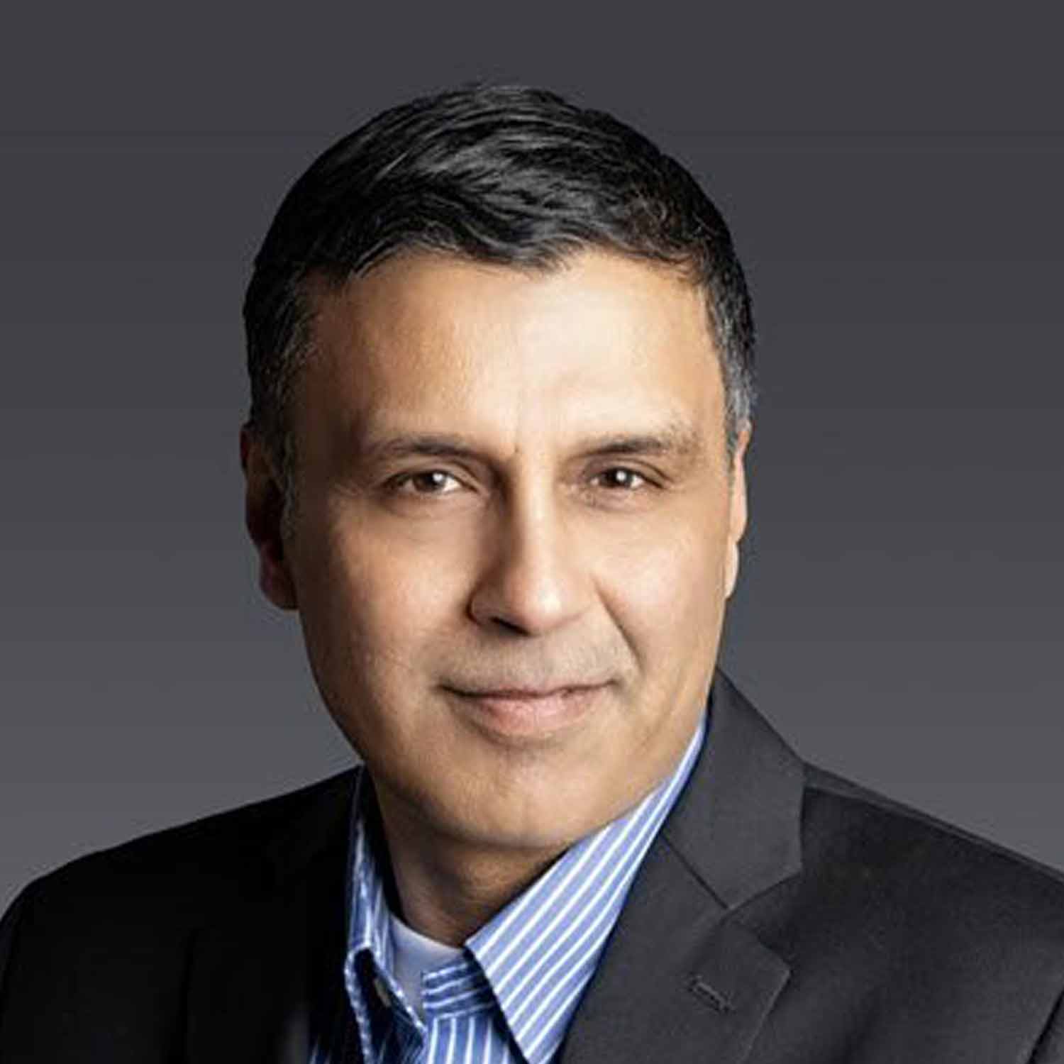 Middle-aged man with neatly combed dark hair, clean-shaven, wearing suit, composed expression.